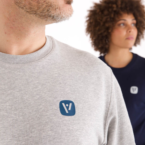 Detailansicht des grau melierten veercrew Sweatshirts "Solid" mit kleinem Logo-Print, getragen von einem Mann