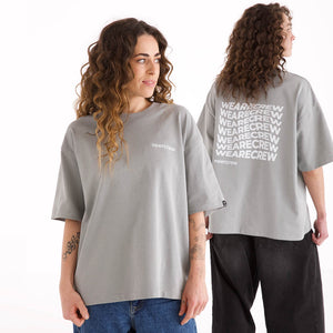 Frau und Mann in grauem oversized veercrew T-Shirt "Statement", die Frau von vorne mit kleinem Logo-Print, der Mann von hinten mit großem "WEARECREW" Schriftzug