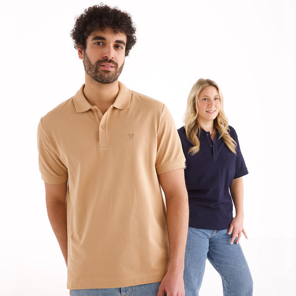 Mann und Frau in veercrew Polo-Shirt "Legacy", der Mann in Beige, die Frau in Dunkelblau
