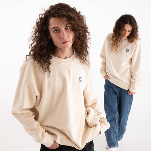 Mann und Frau in naturweißem veercrew Sweatshirt "Pillar" mit kleinem Logo-Print, der Mann vorne, die Frau dahinter