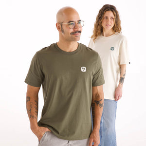 Mann und Frau in veercrew T-Shirt "Prime", der Mann in Khaki, die Frau in Naturweiß, jeweils mit kleinem Logo-Print
