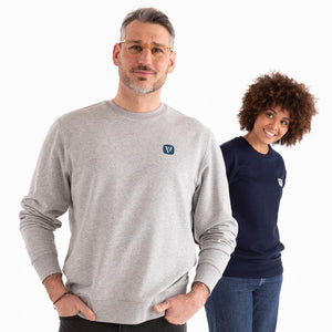 Mann und Frau in veercrew Sweatshirt "Solid", der Mann in Grau meliert, die Frau in Dunkelblau, jeweils mit kleinem Logo-Print