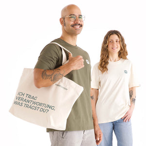 Naturfarbene veercrew Tragetasche "Vessel" mit Aufschrift "Ich trag Verantwortung. Was trägst du?", getragen von einem Mann im olivgrünen T-Shirt